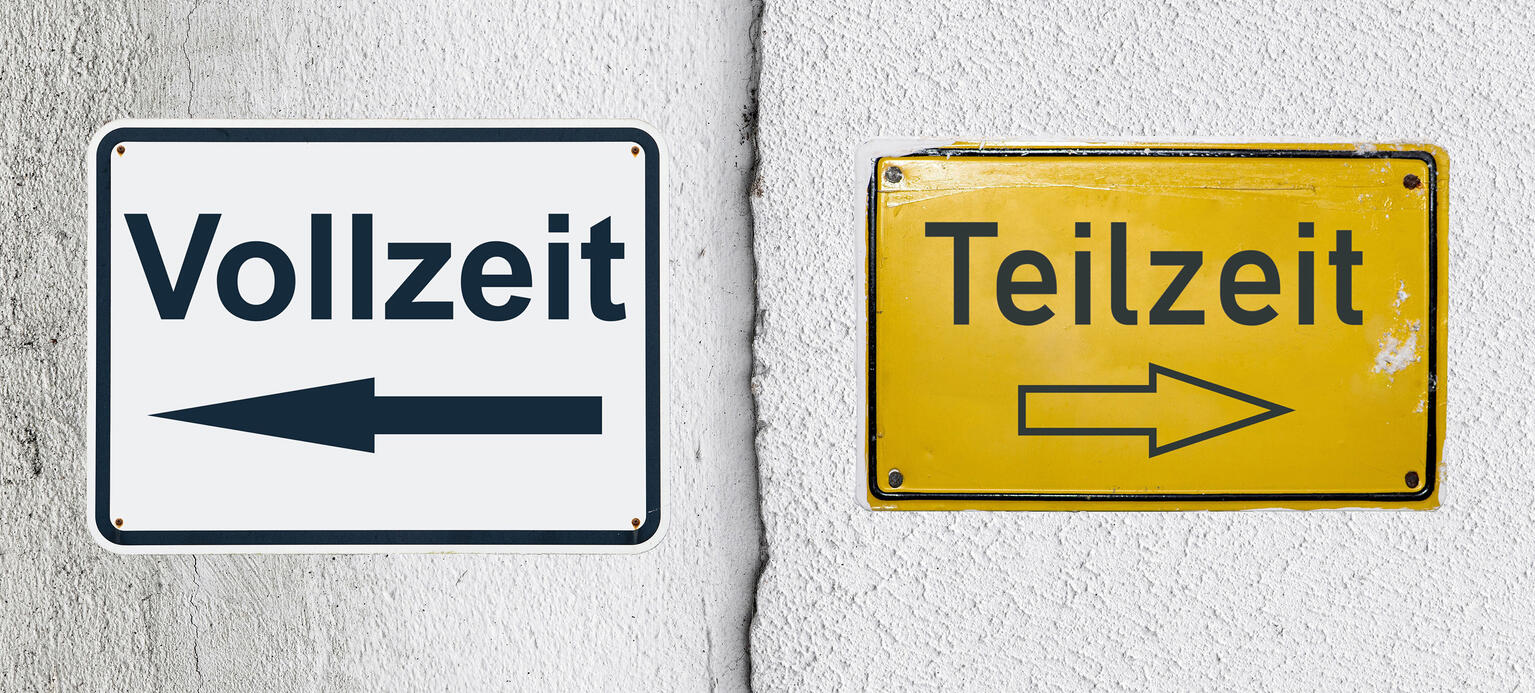 Ein symbolisches, weißes Blechschild mit der Aufschrift 'Vollzeit' und einem Pfeil nach links sowie ein gelbes Schild mit der Aufschrift 'Teilzeit' und einem Pfeil nach rechts auf einer weißen, verputzten Wand mit einem vertikalen Absatz bzw. Riss.