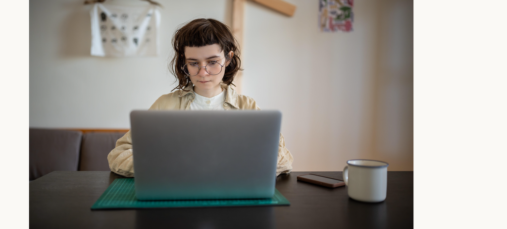 Junge Frau arbeitet zu Hause an einem Laptop. 