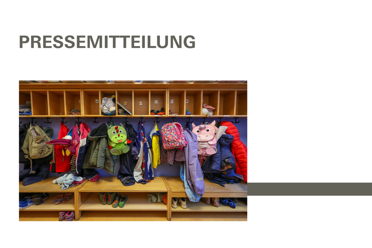 Maentel, Jacken, und Einhorn Rucksaecke von Kindern haengen an einer Garderobe in einem Kindergarten.